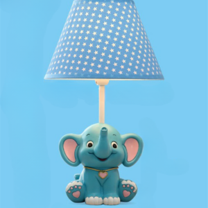 Sur un fond bleu on voit une lampe de bureau pour enfant éléphant bleu avec un abat-jour bleu à pois blanc.