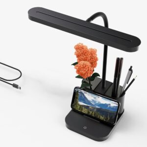 Lampe de bureau noire avec porte-stylo avec un téléphone posé sur le support et un câble de chargeur à gauche